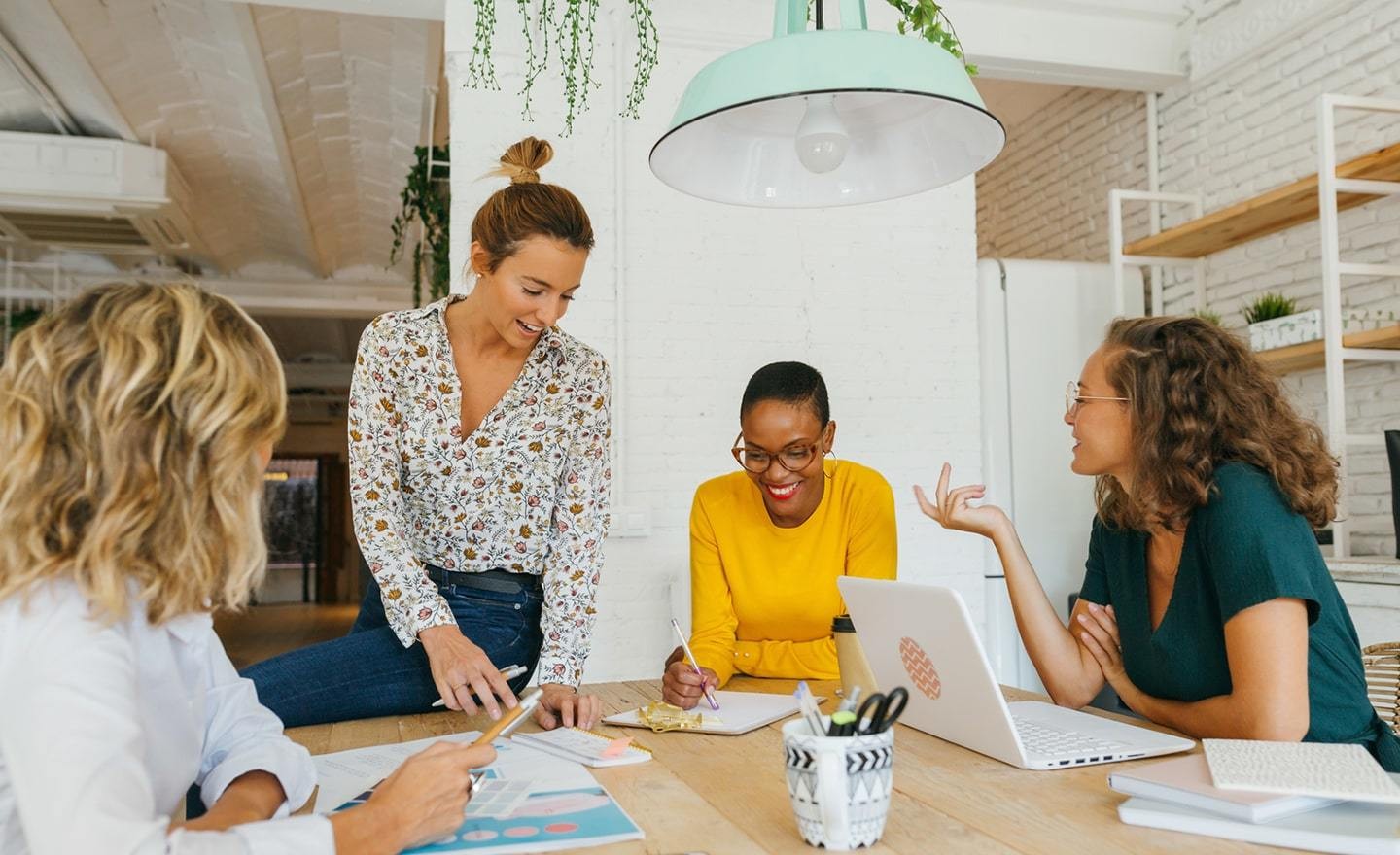 A group of female coworkers gathered around a table