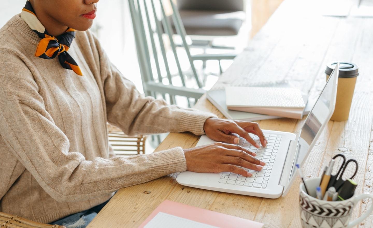 Black woman working at a laptop in an open office