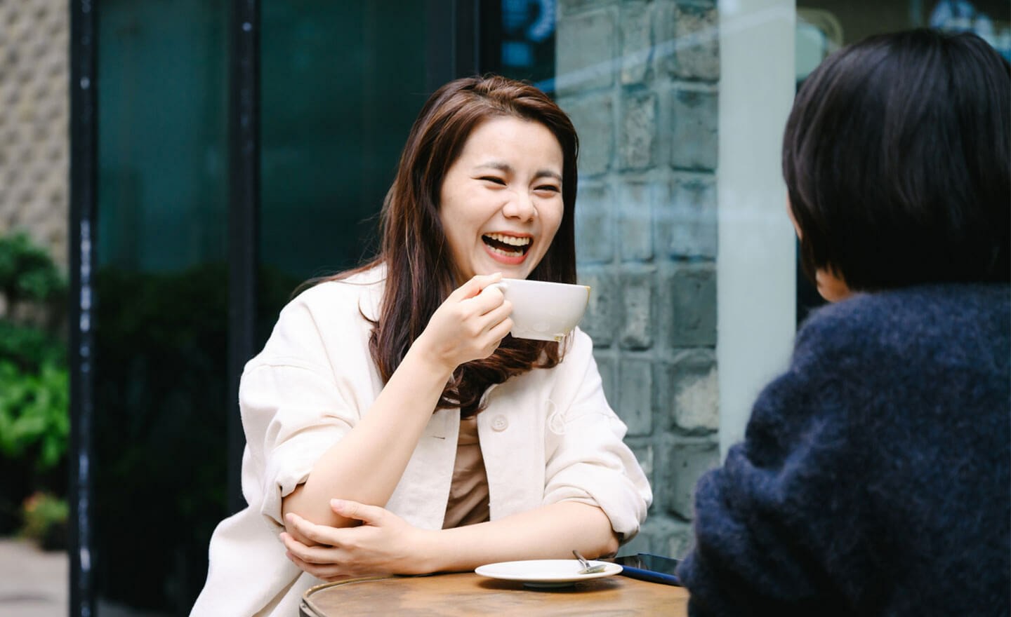 Happy woman drinking coffee with coworker 1