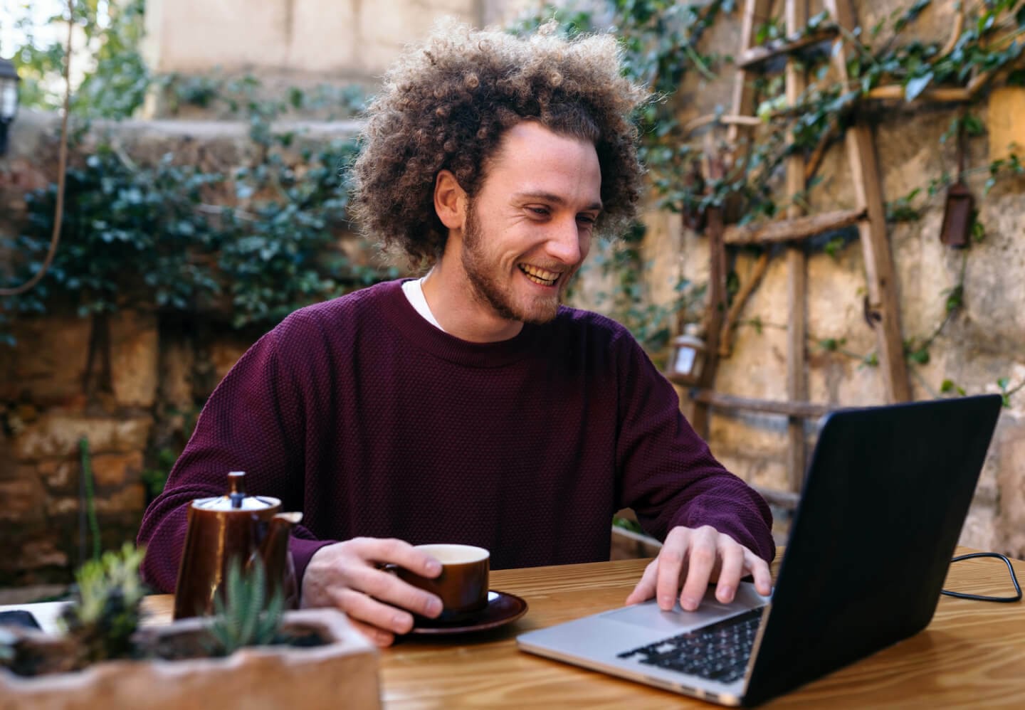 Image of happy man on laptop outside