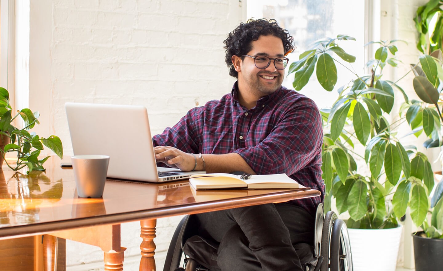 Man in wheelchair working on laptop