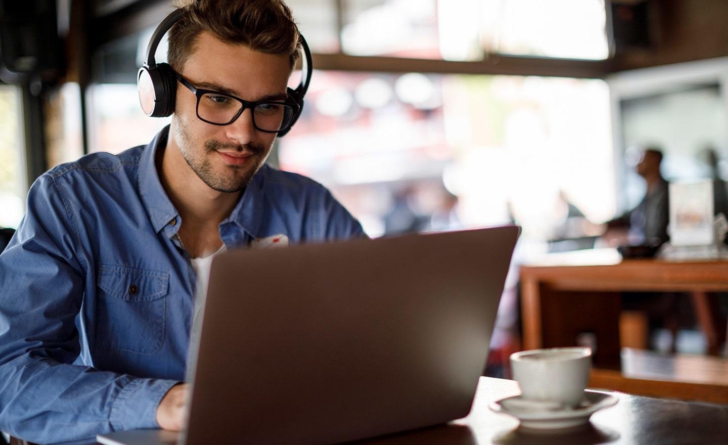 Man working in a coffee shop with headphones