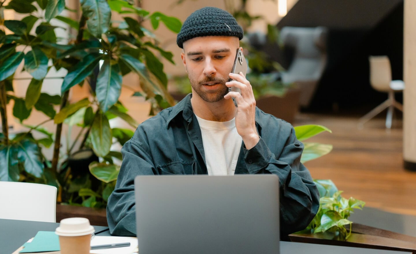 Man working on laptop on phone call