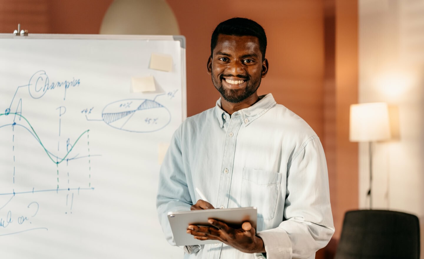 Person with tablet next to whiteboard 720x440