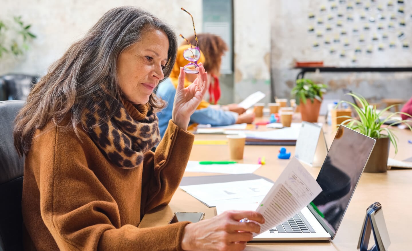 Photo of woman reading a document at her desk