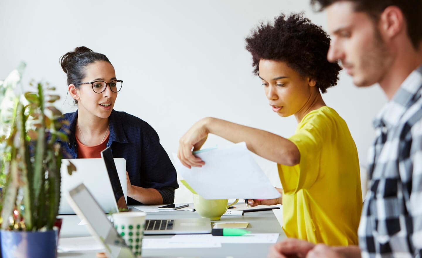 Three collaborating coworkers at a table