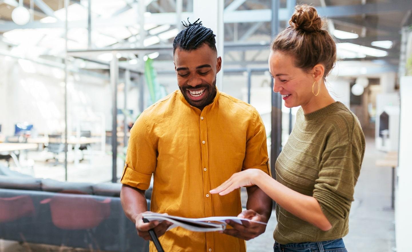 Two coworkers looking at a paper document