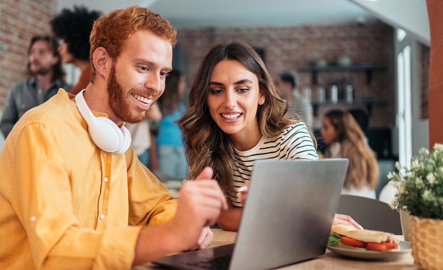 Two coworkers looking at hiring data on laptop 1