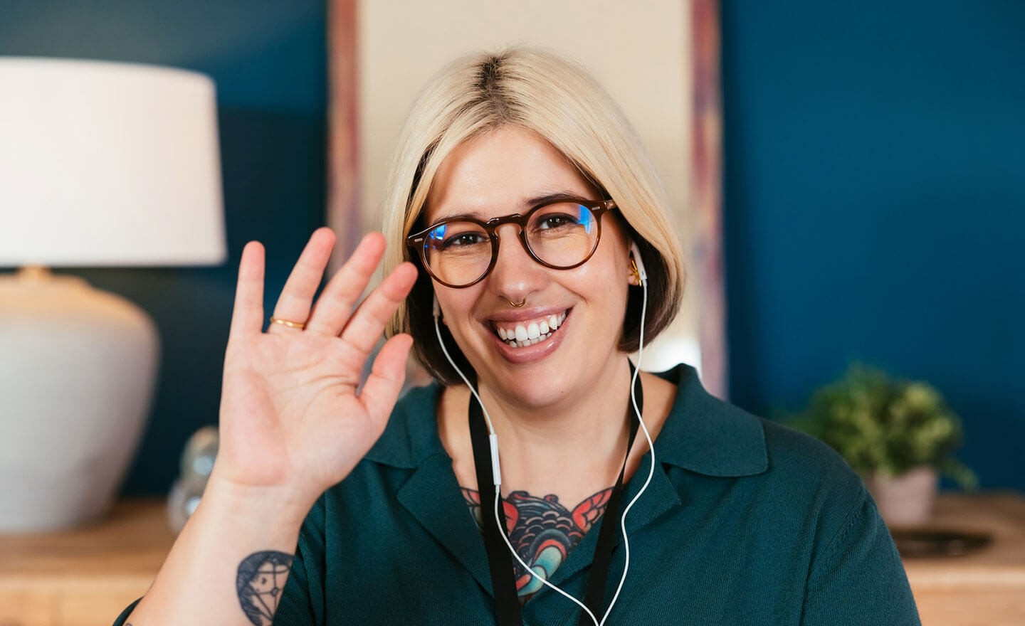 Woman waving at coworkers on video call