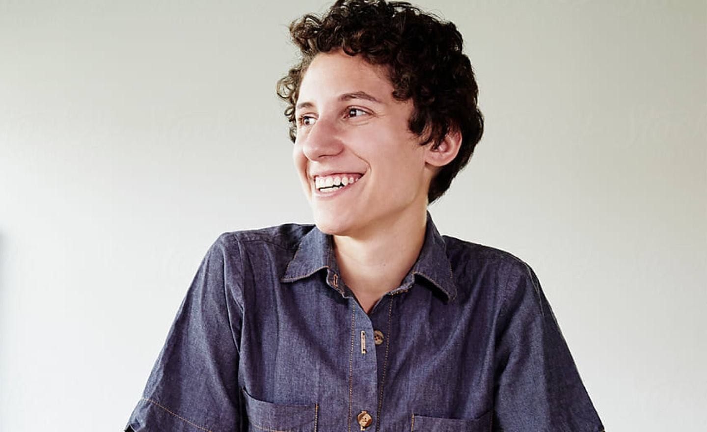 Woman with short hair in denim shirt looking left