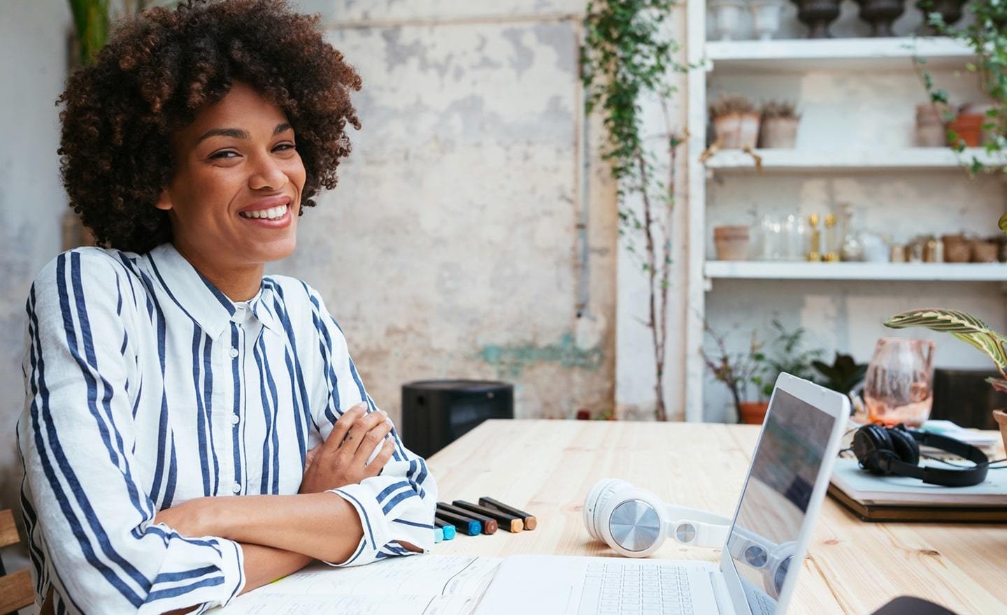 Woman working at desk with plants in the background