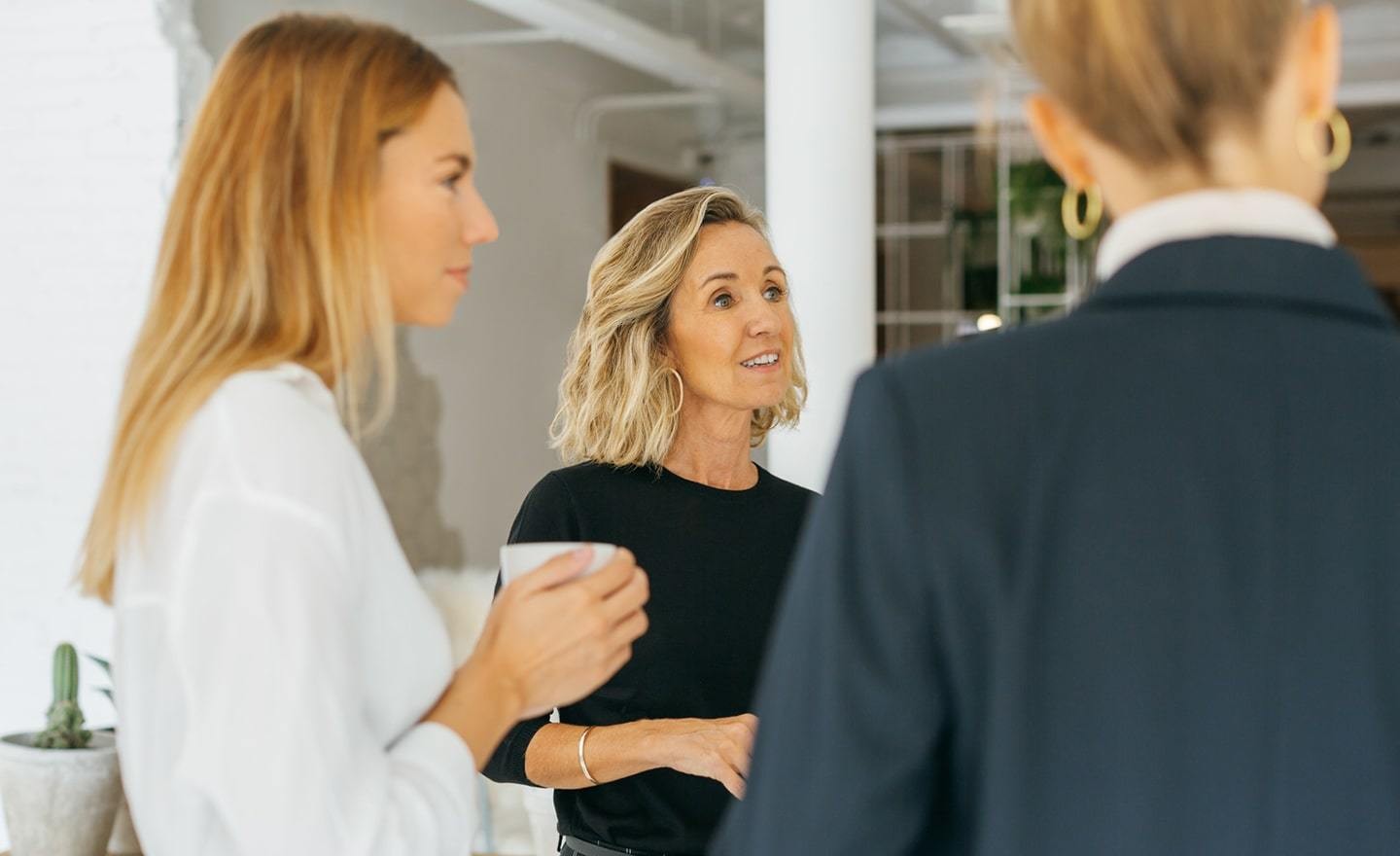 Women standing in a group having a conversation