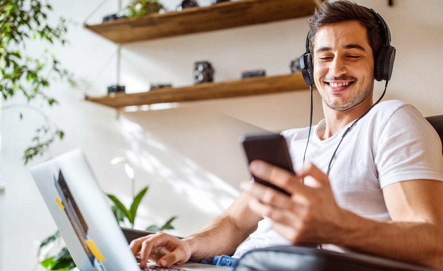 Young man in lounge chair wearing headphones