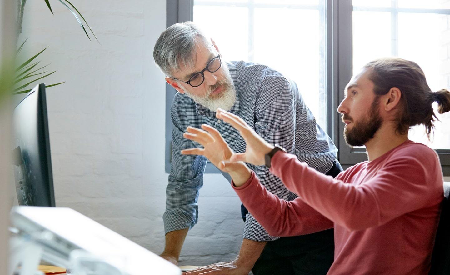 Young man presenting work to boss at desk