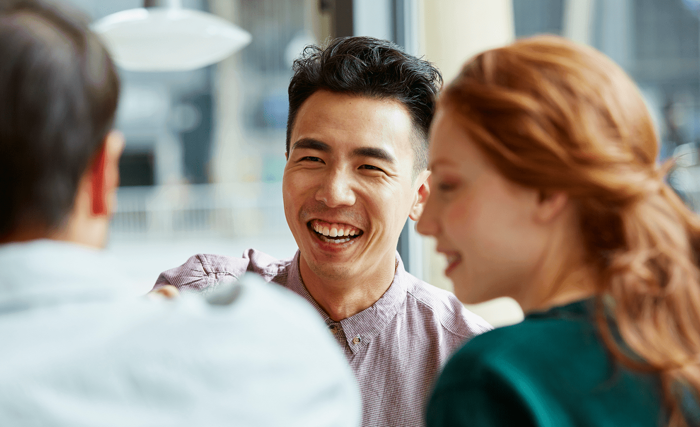 Three coworkers talking and laughing