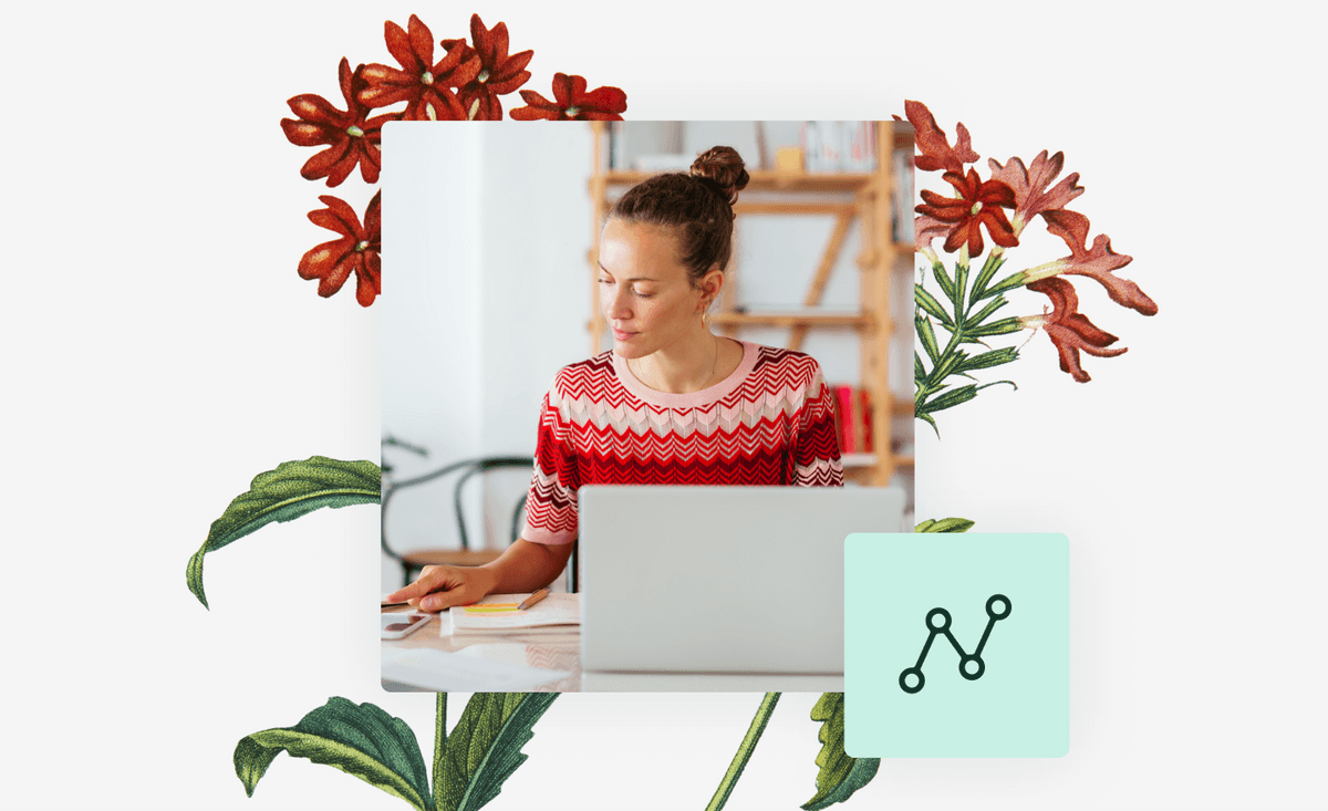 Woman working on laptop with botanical plant behind